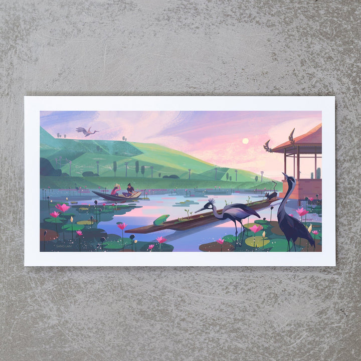 An image of an art print that depicts a couple in a rowboat on a pond. There are mountains and telephone wires in the distance and the sun in setting. In the foreground, two herons are drinking. There is a gazebo to the side of the pond, and several other animals around, including a bird, a frog, a black cat, and many lily pads and lotus flowers in bloom.